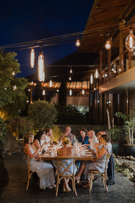 Roam Elopements, Maui Elopements, Guests enjoying a romantic outdoor dinner party under string lights.
