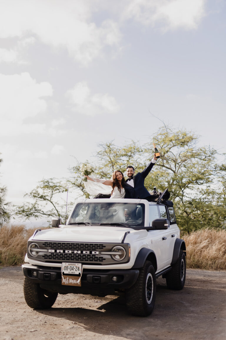 Roam Elopements, Maui Elopements, Happy newlyweds Natalie & Jose in a white Ford Bronco, celebrating their West Maui elopement.