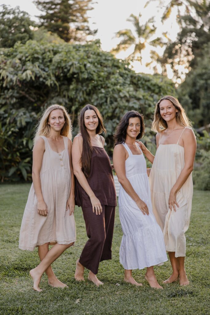 Roam Elopements, Maui Elopements, Four women in linen dresses stand on a grassy lawn.