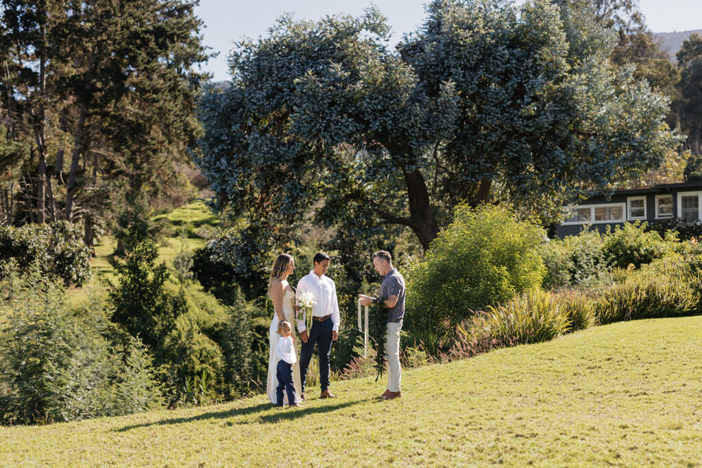 Roam Elopements, Maui Elopements, Elopement ceremony with couple, officiant, and child outdoors.