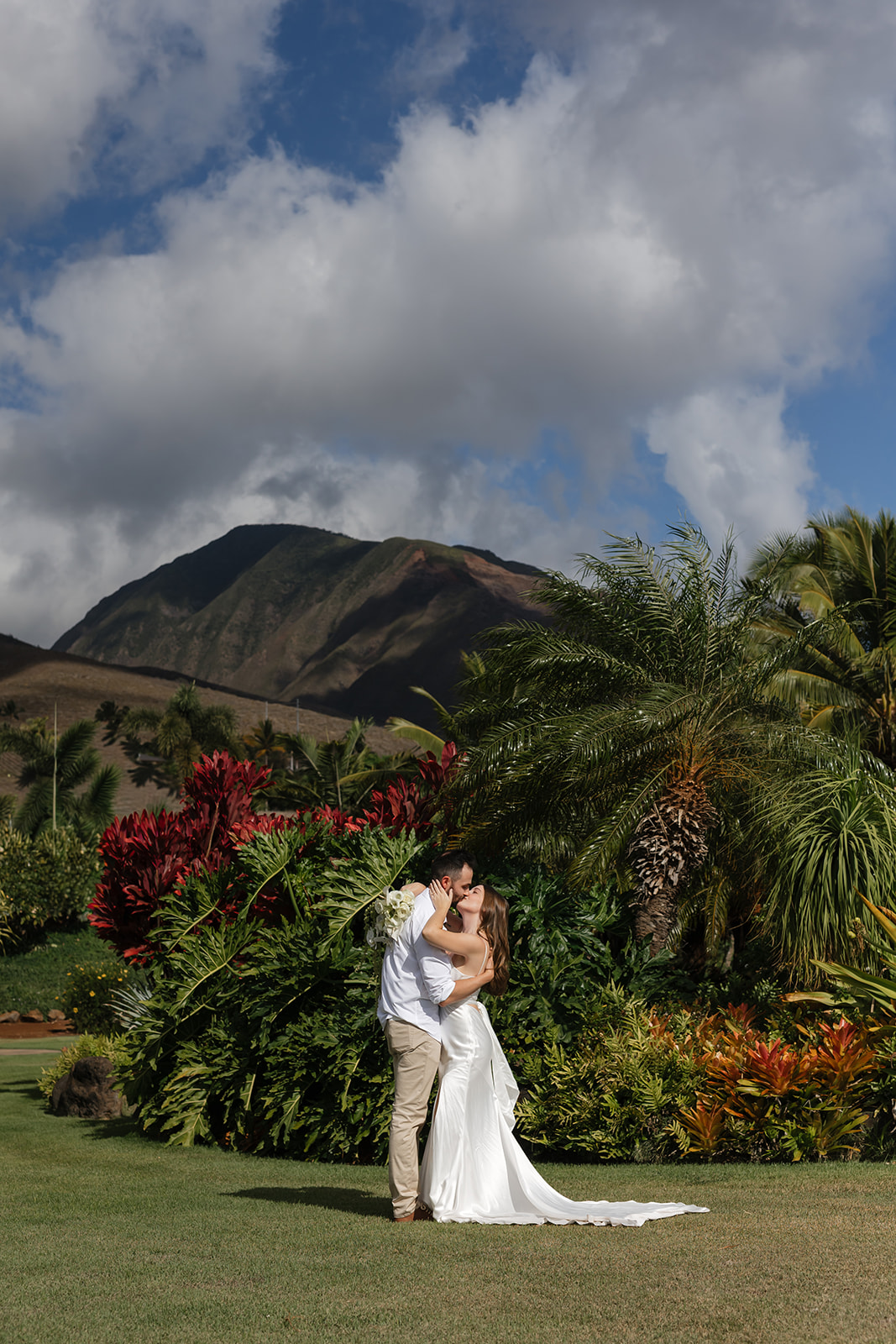 Roam Elopements, Maui Elopements, Couple kissing during their elopement with a mountain backdrop.