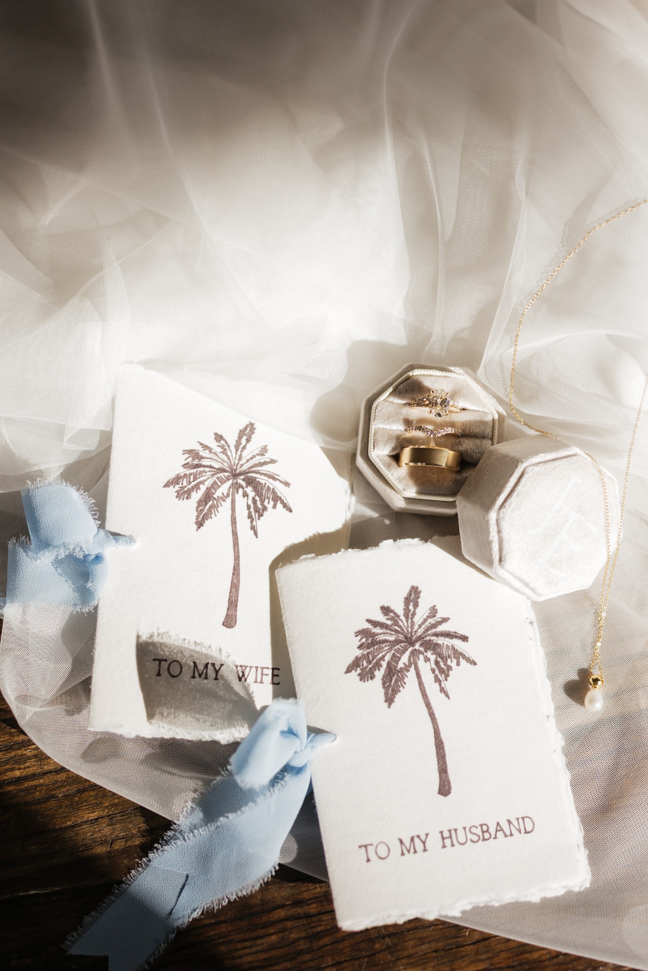 new-general-images-8 - Roam Elopements Roam Elopements, Maui Elopements, Wedding rings, necklace, and cards reading "To My Wife" and "To My Husband" on textured paper.