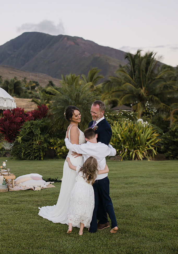 Roam Elopements, Maui Elopements, Family embraces at a micro wedding with mountain backdrop.