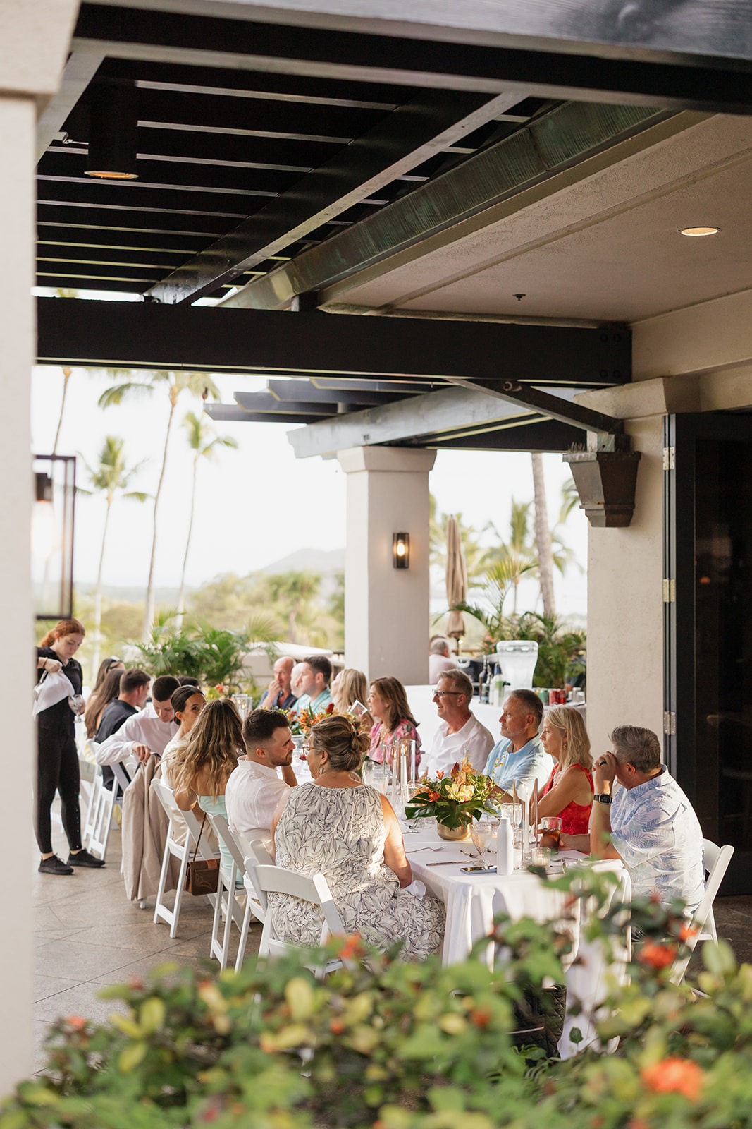 Roam Elopements, Maui Elopements, Guests at an outdoor micro wedding reception with palm trees in the background.