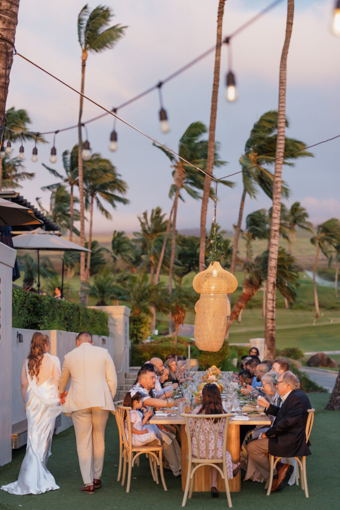 Camille Ahmed - f Roam Elopements, Maui Elopements, Couple at a micro wedding reception on Maui with palm trees and string lights.
